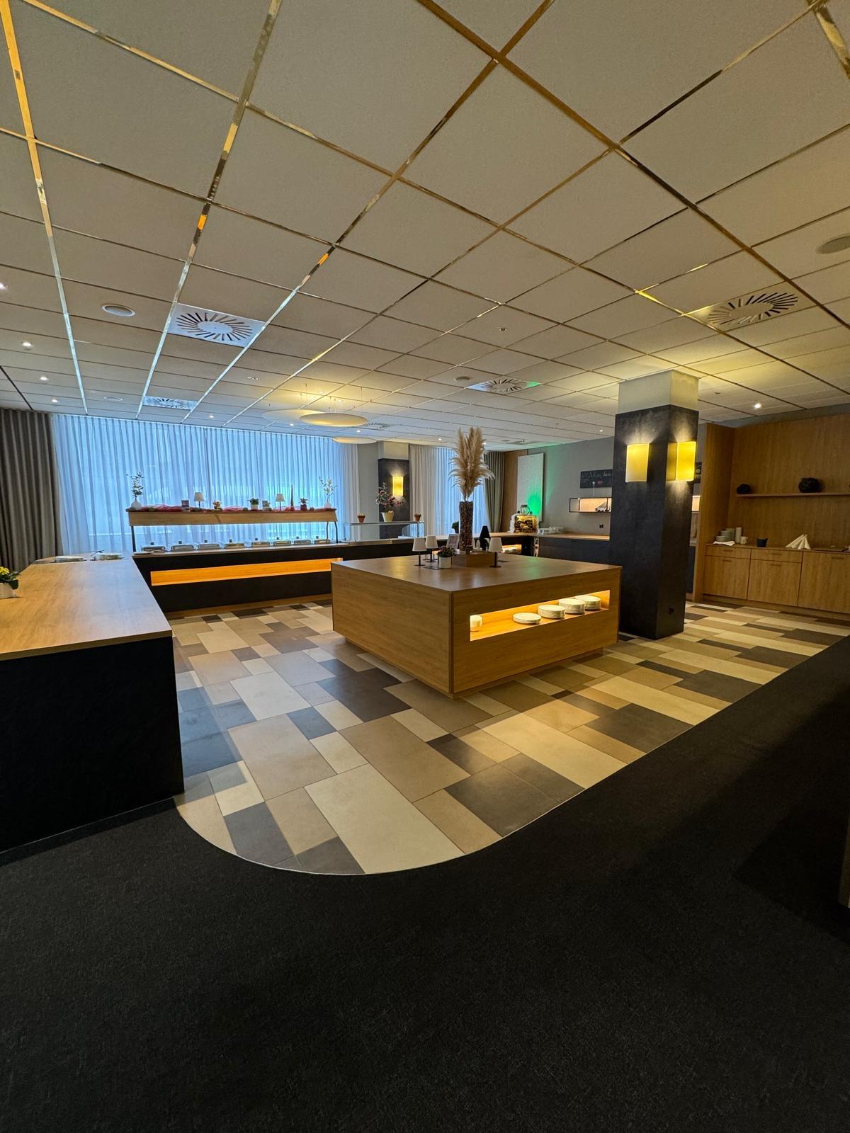 Heller moderner Empfangsbereich mit Holzmöbeln und auffälliger Beleuchtung